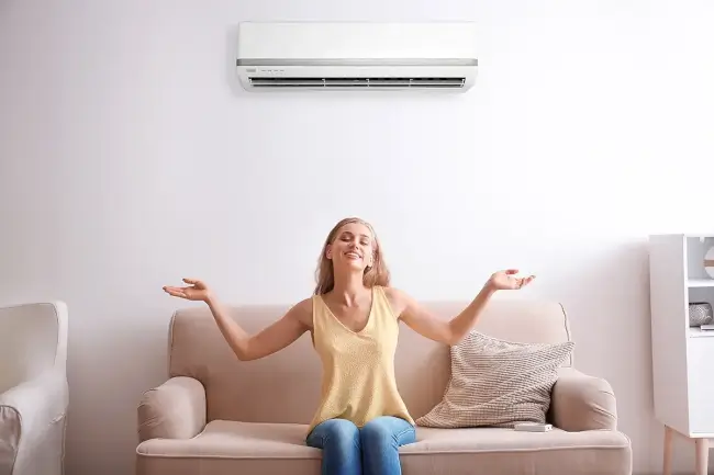 Kobieta w pomieszczeniu z klimatyzatorem z funkcją jonizacji powietrza